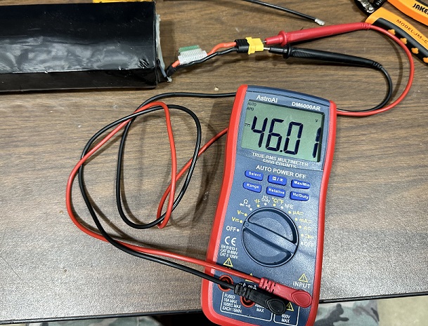 Multimeter with a fixed resistance load used to accurately test a battery